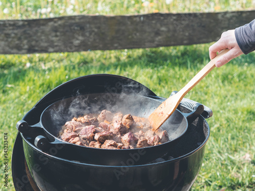 dutch oven goulash on rustic wood fired bbq grill