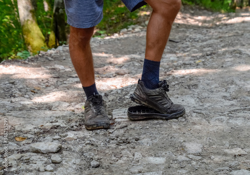 detached sole on the tourist s sneakers. They broke their boots in the woods.