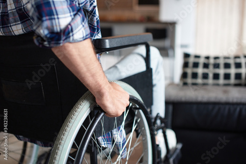 Disabled person sitting in a wheelchair at home