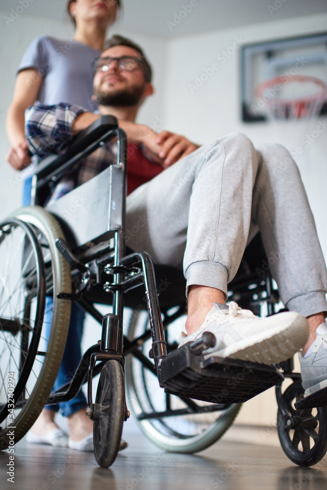 Obraz premium Woman helping disabled young man in wheelchair