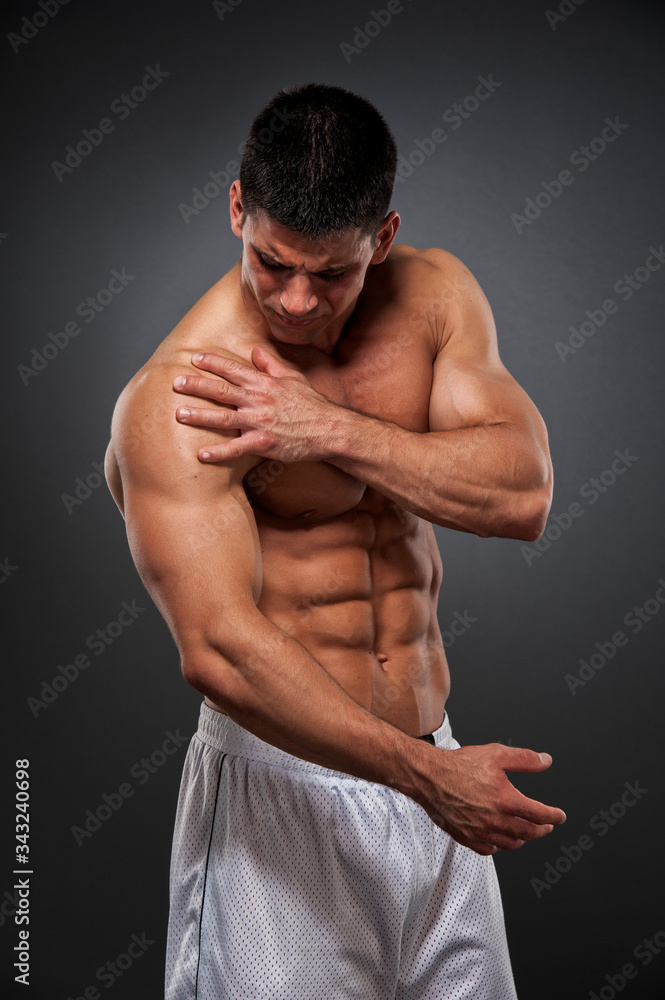 Shoulder Pain. Athletic Men in pain due to shoulder injury