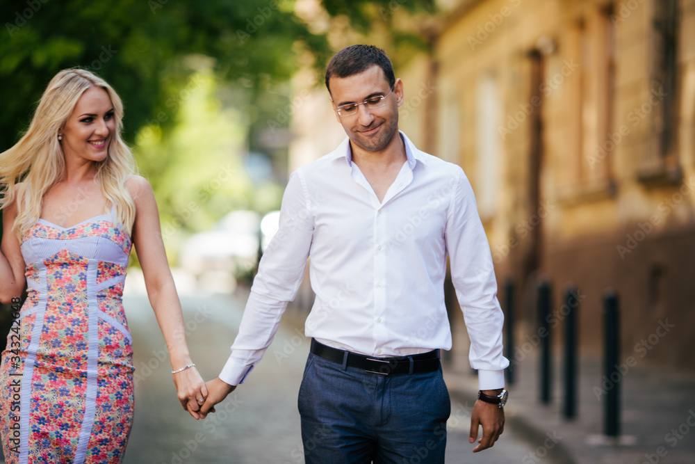 Young couple in love hug each other on city background