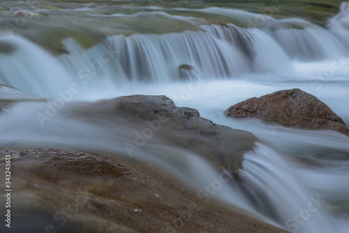 A clean mountain stream with cascades and rocks on a long exposure