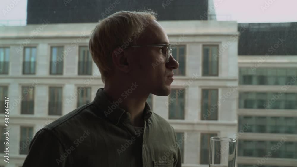 Man drinks water on a skyscraper background, bottom view. Man drinks water on a skyscraper background, bottom view.