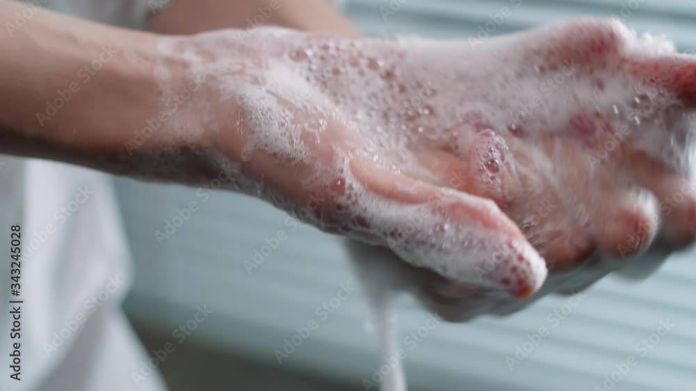 Close up shot of unrecognizable female medical worker washing her hands by rubbing them together with the soap during workday in hospital Close up shot of unrecognizable female medical worker washing her hands by rubbing them together with the soap during workday in hospital