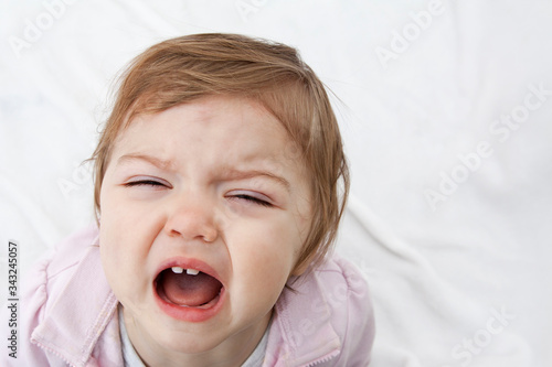The child screams with his mouth open. Negative emotions of the child. Vagaries and crying baby. photo