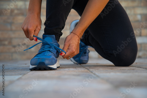 woman tying her shoes before doing gym.Determinated girl at the gym ready to start fitness lesson.Strength and motivation