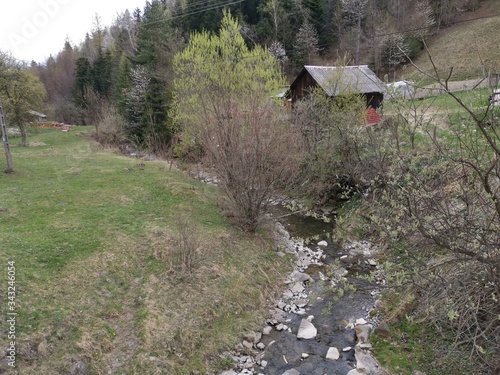 A shed over a stream next to the woods