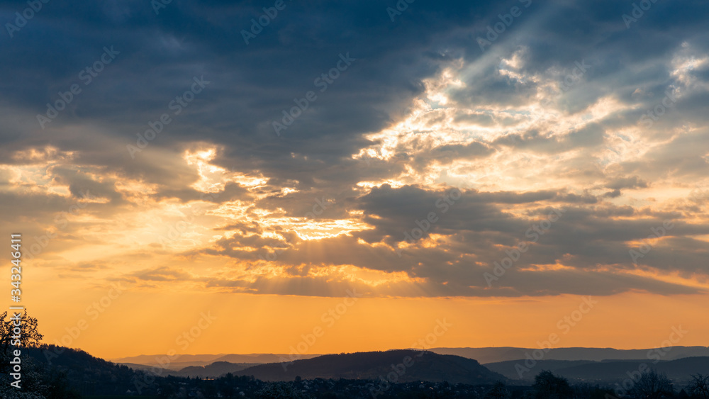 Sun rays break through the cloud cover at sunrise