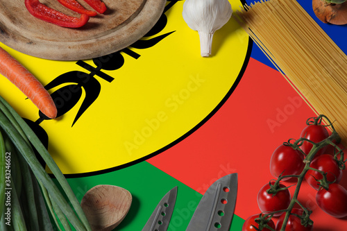 New Caledonia flag on fresh vegetables and knife concept wooden table. Cooking concept with preparing background theme.