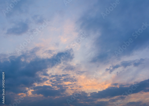 Cumulus sunset clouds with sun setting down. Abstract nature background. Dramatic and moody orange and blue cloudy sunset sky. Sunset sky with multicolor clouds.