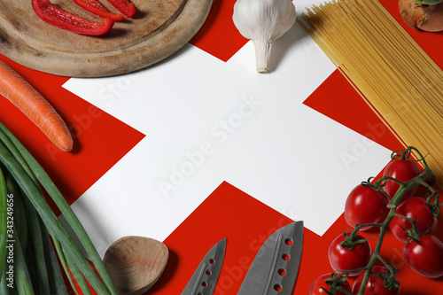 Switzerland flag on fresh vegetables and knife concept wooden table. Cooking concept with preparing background theme.
