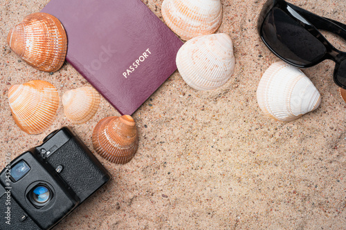 Obraz na płótnie Passport, vintage film camera, sunglasses and seashells on golden beach sand. Summer travel abstract concept. Copy space in the bottom right corner. w salonie