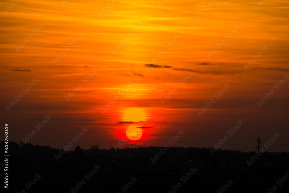 The bright red sun sets over the horizon. Red yellow sunset
