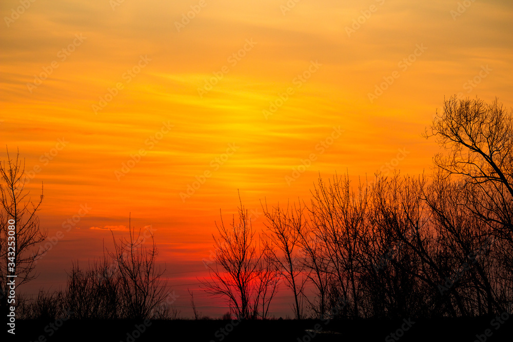 Beautiful lens flare in the clouds from the setting sun over the horizon
