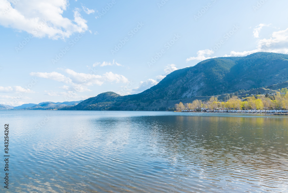 Scenic view of Skaha Lake on sunny afternoon with mountains and blue sky Scenic view of Skaha Lake on sunny afternoon with mountains and blue sky
