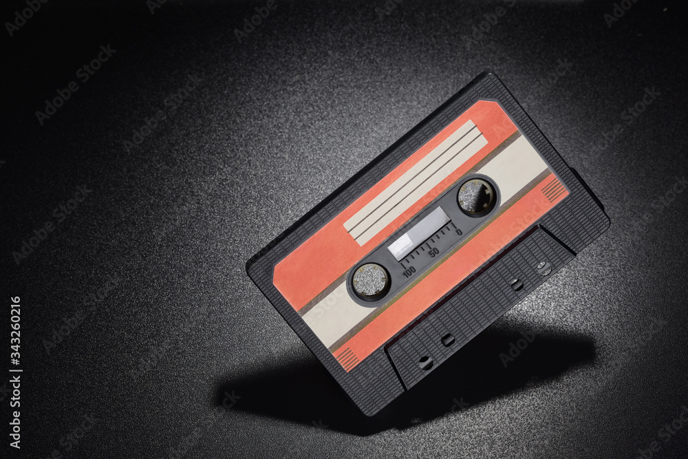 Fototapeta premium Black audio tape compact cassette on black background