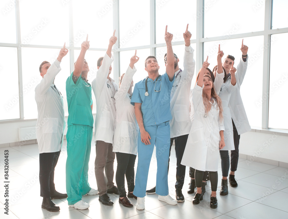 full-length. group of diverse doctors pointing in one direction full-length. group of diverse doctors pointing in one direction