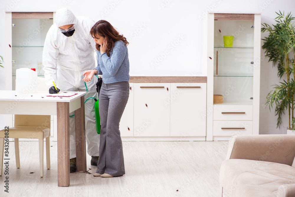 Young male contractor and female client during pest control Young male contractor and female client during pest control