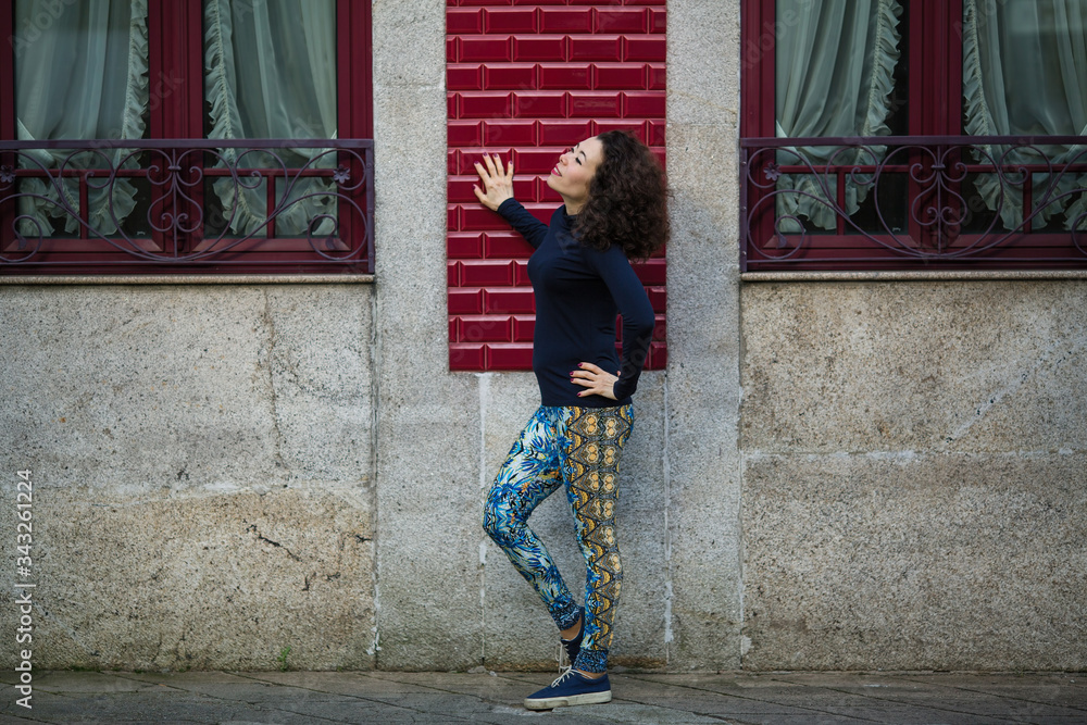 Young asian multicultural woman in leggings on the street near the wall, Porto, Portugal. Young asian multicultural woman in leggings on the street near the wall, Porto, Portugal.