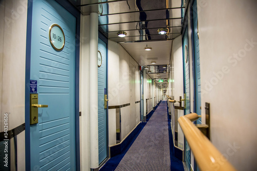 Obraz na płótnie A long corridor in blue style with cabin doors on the deck of a modern passenger ferry w salonie