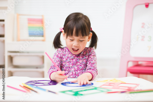 toddler girl practice drawing different shapes for homeschooling