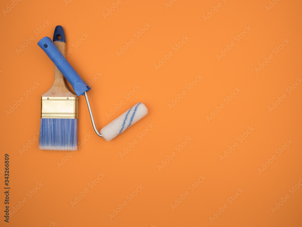 The brush and roller. Tool for paint finishing work on an orange background. The brush and roller. Tool for paint finishing work on an orange background.
