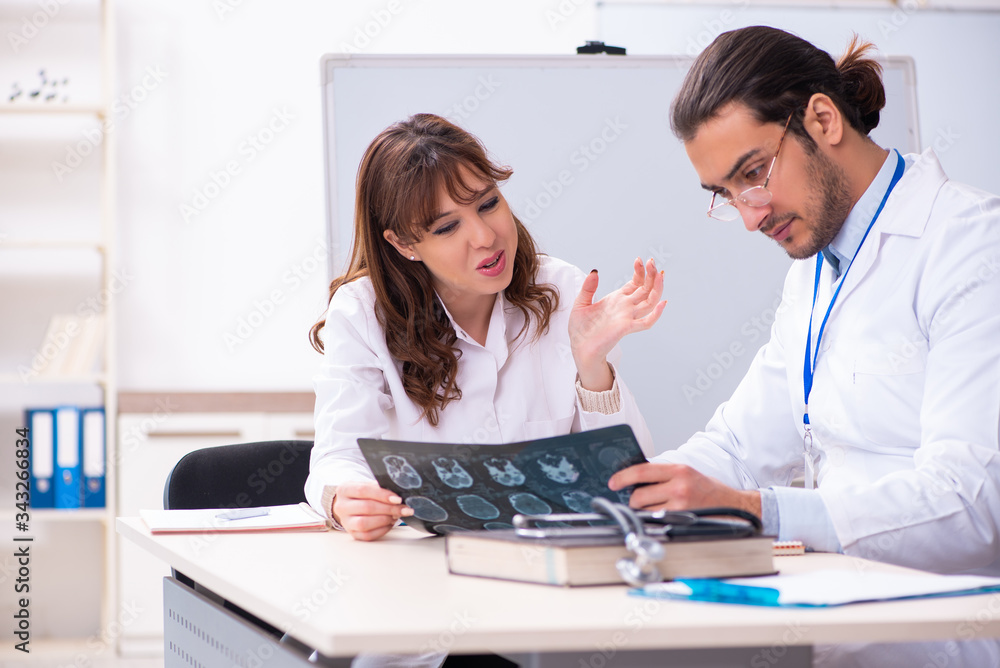 Young male doctor radiologist and female student in the classroo Young male doctor radiologist and female student in the classroo