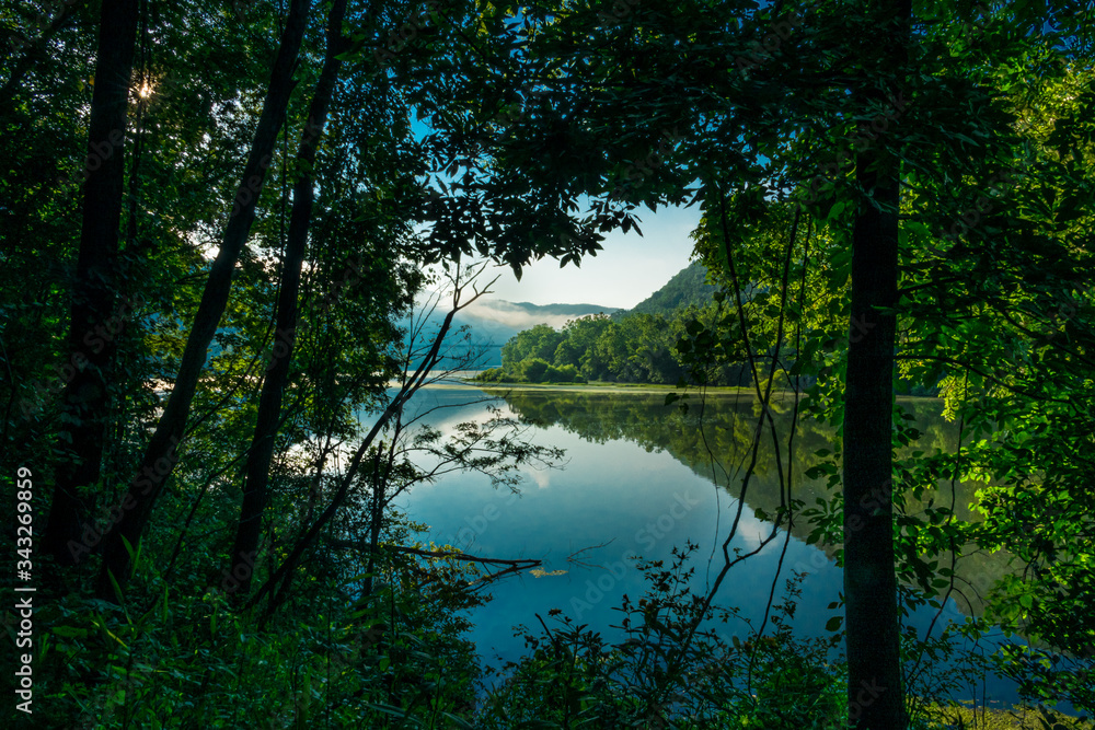 This is an offshoot of Bluestone Lake captured with fog hanging over the mountain in the distance, in Bluestone Lake State Park , Hinton, WV.. There are lots of reflections seen in the calm waters.