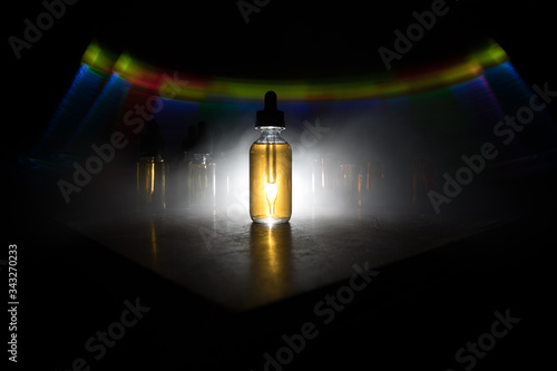 Smoke clouds and vape liquid bottles on dark background. Light effects. Useful as background or vape advertisement or vape background. Selective focus