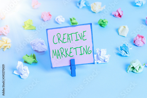 Text sign showing Creative Marketing. Business photo text Campaigning to meet the advertising requirements Colored crumpled papers empty reminder blue floor background clothespin photo