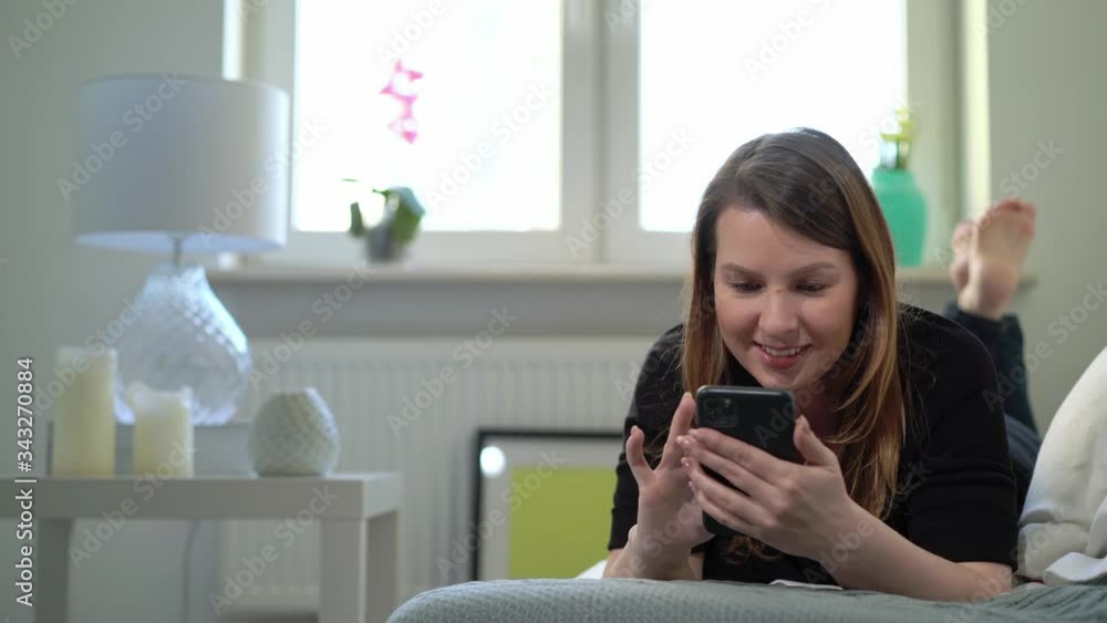 Young woman with smartphone at sofa at home. Telephone gadget device Young woman with smartphone at sofa at home. Telephone gadget device