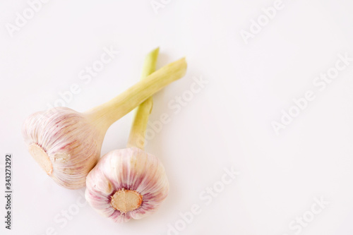 2 heads of young garlic on a white background