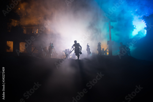 War Concept. Military silhouettes fighting scene on war fog sky background, World War Soldiers Silhouette Below Cloudy Skyline At night.