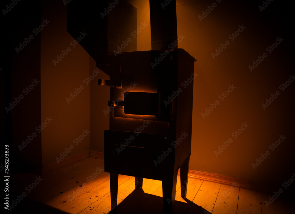 Fire burning in small black iron stove. Closeup photo with selective focus - obrazy, fototapety, plakaty 