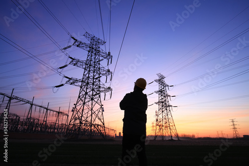 Electricity workers and pylon silhouette, Power workers at work
