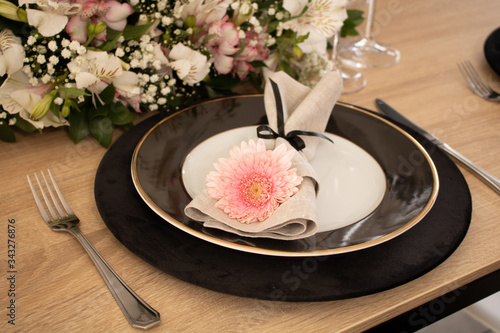 Elegant table setting with flowers and white and black dinnerware