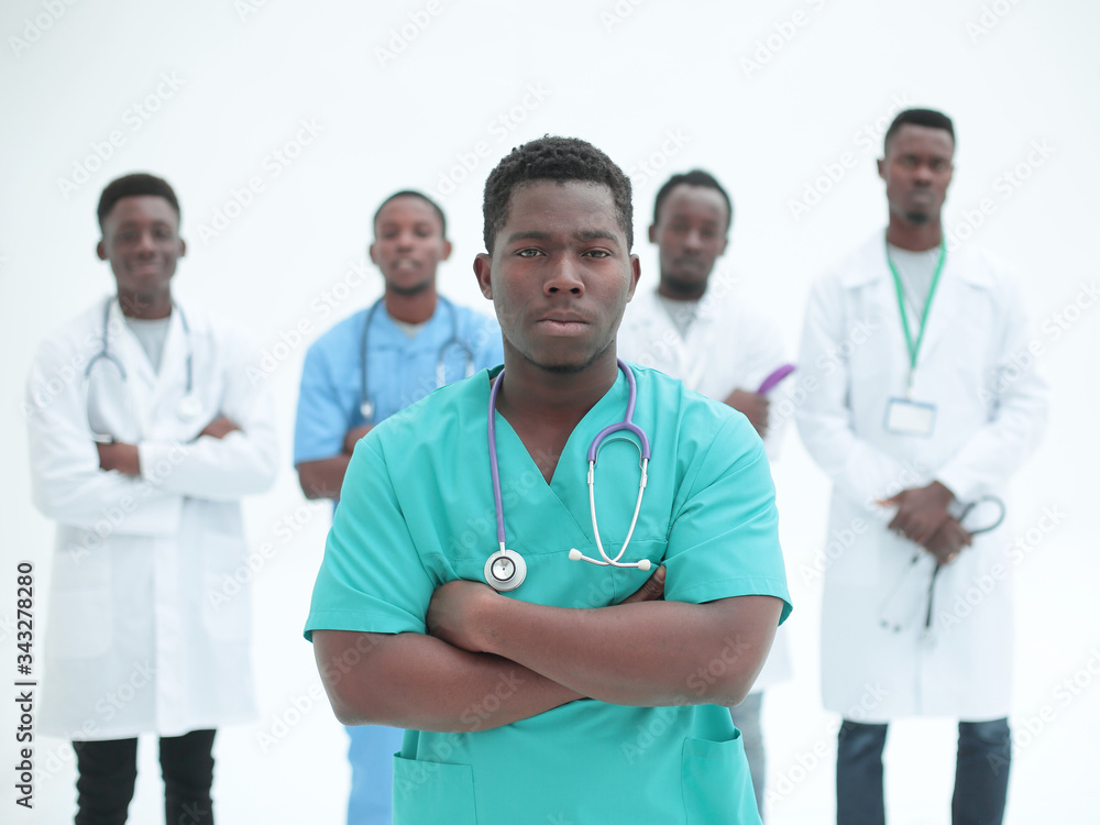 smiling surgeon standing in front of his colleagues smiling surgeon standing in front of his colleagues