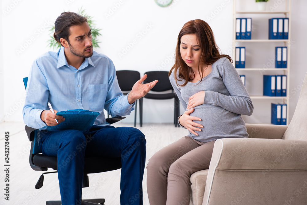 Pregnant woman visiting young male psychologist Pregnant woman visiting young male psychologist