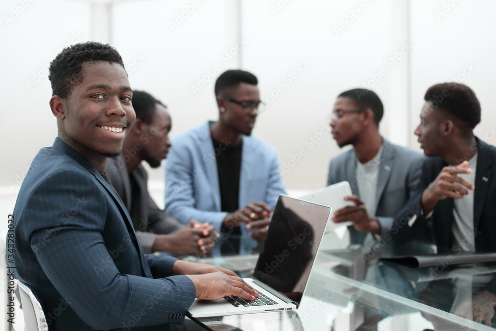 young businessman uses laptop sitting at office Desk. young businessman uses laptop sitting at office Desk.