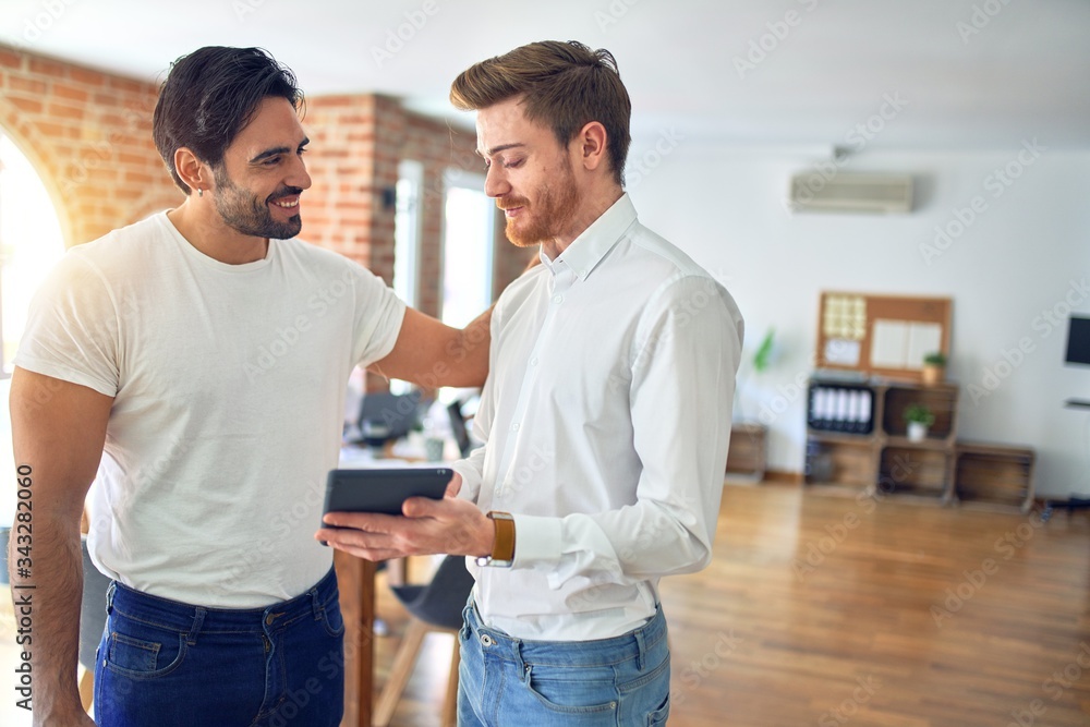 Business workers smiling happy. Standing with smile on face working together using tablet at the office Business workers smiling happy. Standing with smile on face working together using tablet at the office