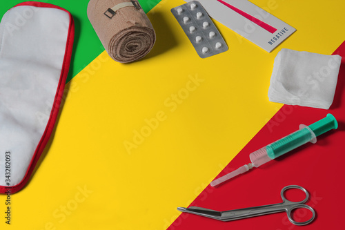 Mali flag with first aid medical kit on wooden table background. National healthcare system concept, medical theme.