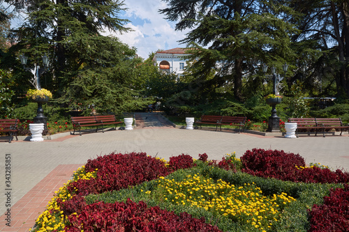 Obraz na płótnie Shady alley in a city park, Sevastopol. Flower beds and benches for relaxation. w salonie