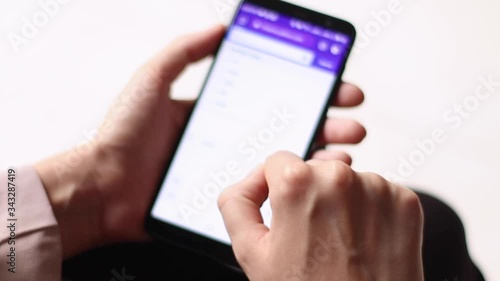 Young businesswoman watches financial statements of companies from the phone
