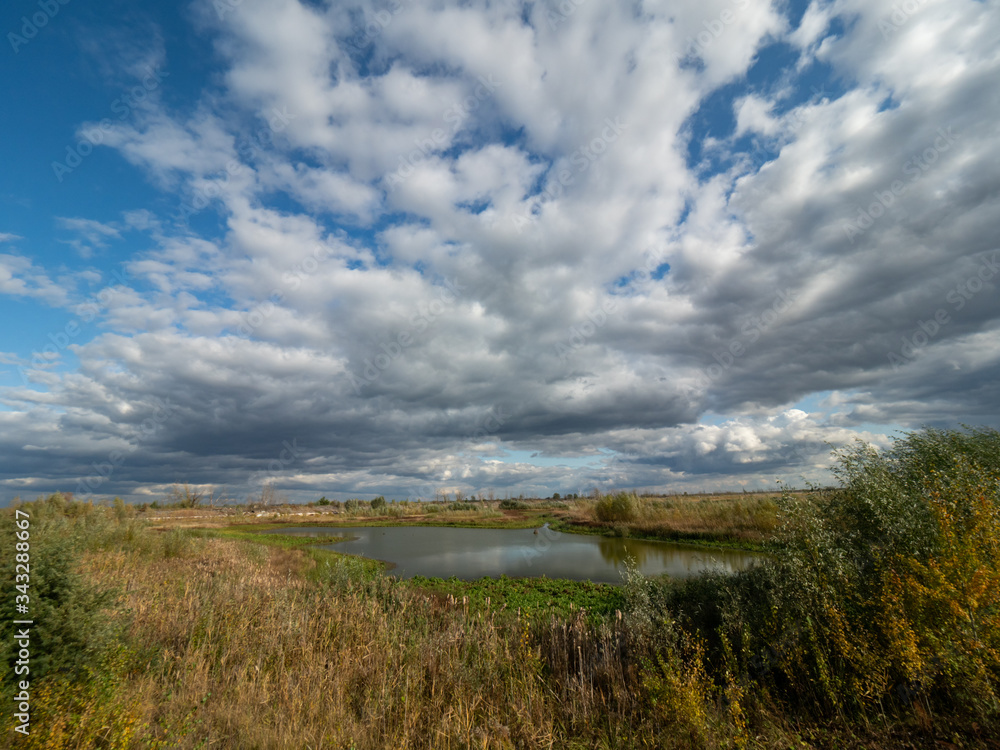 Scrap and left overs of fishing farm in Chernobyl Exclusion Zone, Ukraine. Dramatic sky over the lake.