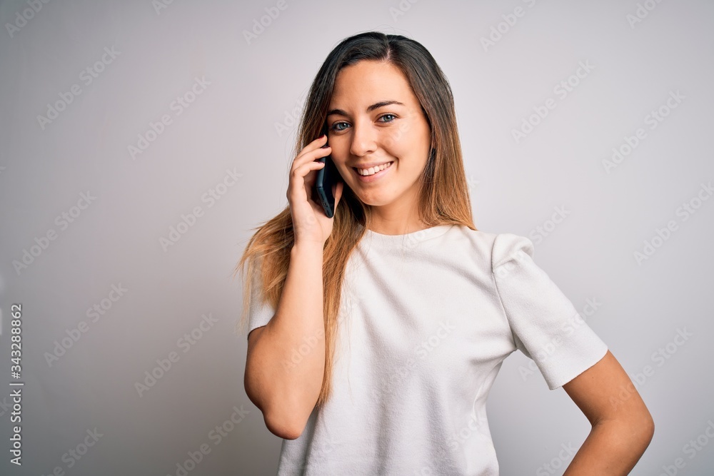 Young beautiful brunette woman having conversation talking on the smartphone with a happy face standing and smiling with a confident smile showing teeth Young beautiful brunette woman having conversation talking on the smartphone with a happy face standing and smiling with a confident smile showing teeth