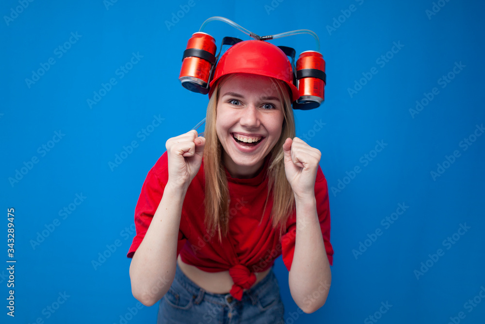 funny girl a fan in a red uniform and a beer hat watches the game and enjoy the victory, the winner screams and holds hands in fists funny girl a fan in a red uniform and a beer hat watches the game and enjoy the victory, the winner screams and holds hands in fists