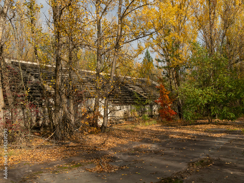 Abandoned tribune of sport stadium Avangard, taken by nature in Pripyat ghost town in Chernobyl Exclusion Zone. Ukraine photo