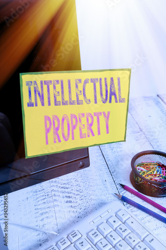 Handwriting text Intellectual Property. Conceptual photo Protect from Unauthorized use Patented work or Idea Note paper taped to black computer screen near keyboard and stationary