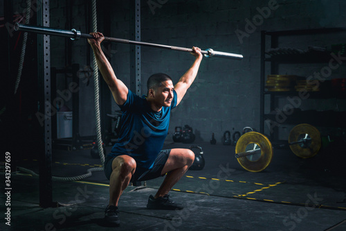 asian strong man workout and lifting barbells at gym and fitness club © Mongkolchon
